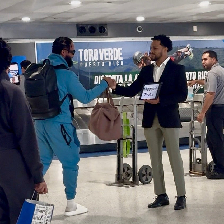 People in an airport terminal with luggage, interacting with each other.